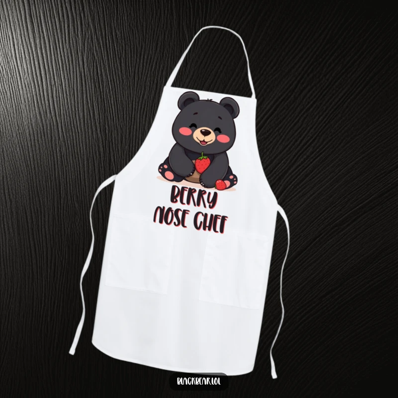 Funny apron featuring a smiling black bear balancing a berry on its nose, designed for humorous and practical kitchen protection.