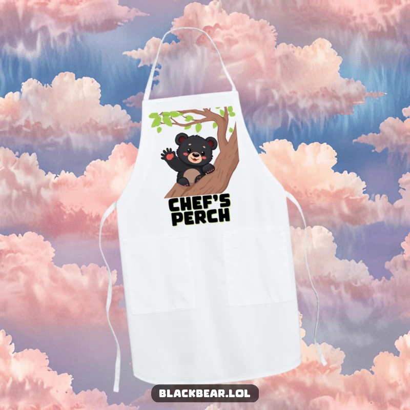 Funny black bear cub waving from a tree branch while wearing an apron, ready to add cheerful vibes to the kitchen.