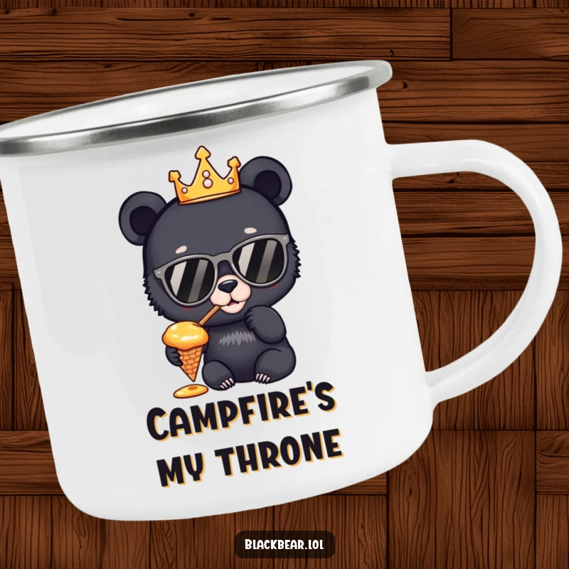 Funny Camping Mug: A sturdy enamel mug with a black bear cub king wearing a crown and sunglasses, tasting honey from a cone, ideal for regal outdoor moments.