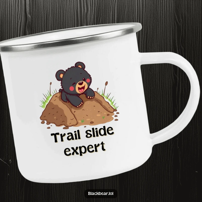 Funny black bear cub headfirst down a muddy hill, depicted on a rugged camping mug, perfect for outdoor enthusiasts.