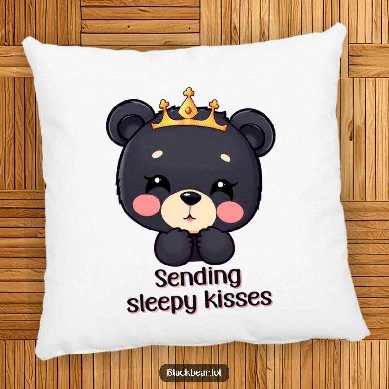 Funny black bear cub pillow, a cub in a sparkly crown blowing a kiss downwards, offering comfort with adorable and loving humor.