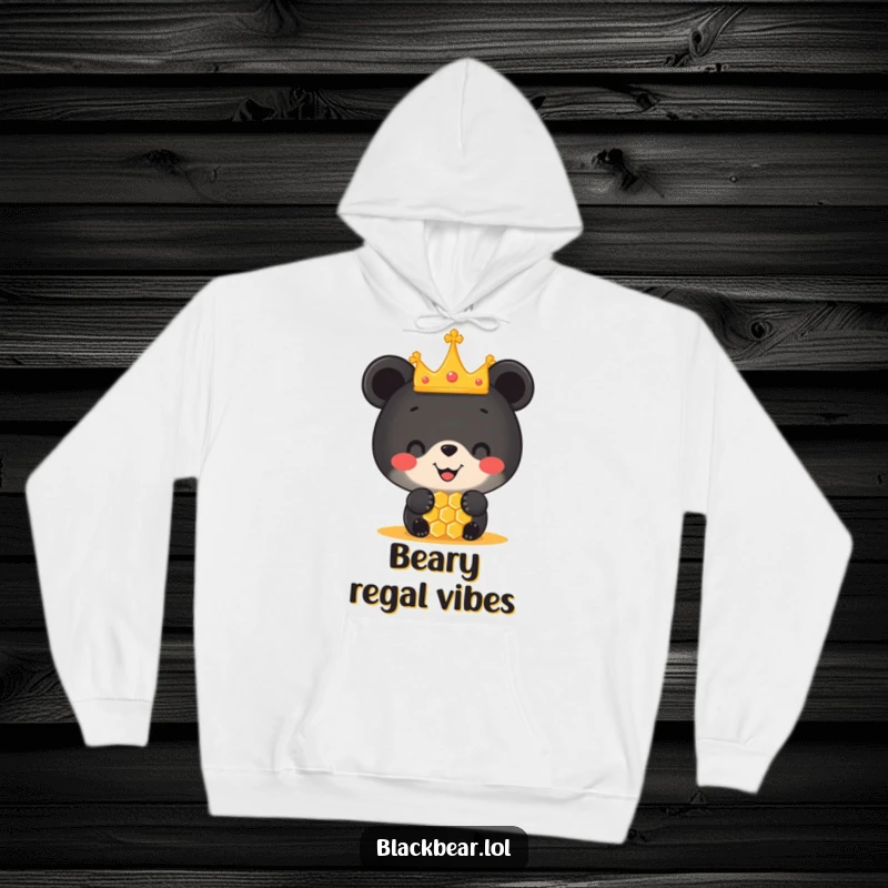 Funny hoodie with a happy black bear cub sporting a tiny crown, balancing a honeycomb on its nose, radiating pure joy and sweetness.