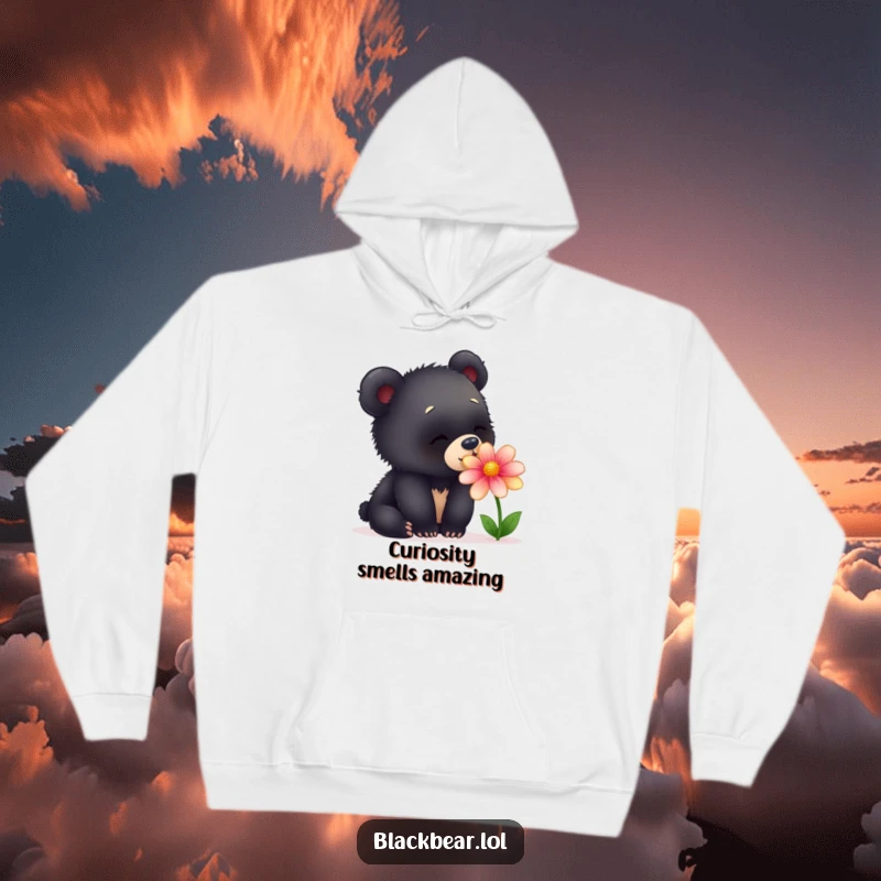 Funny hoodie portraying a young black bear cub with a look of pure fascination, intently sniffing a colorful, delicate flower.