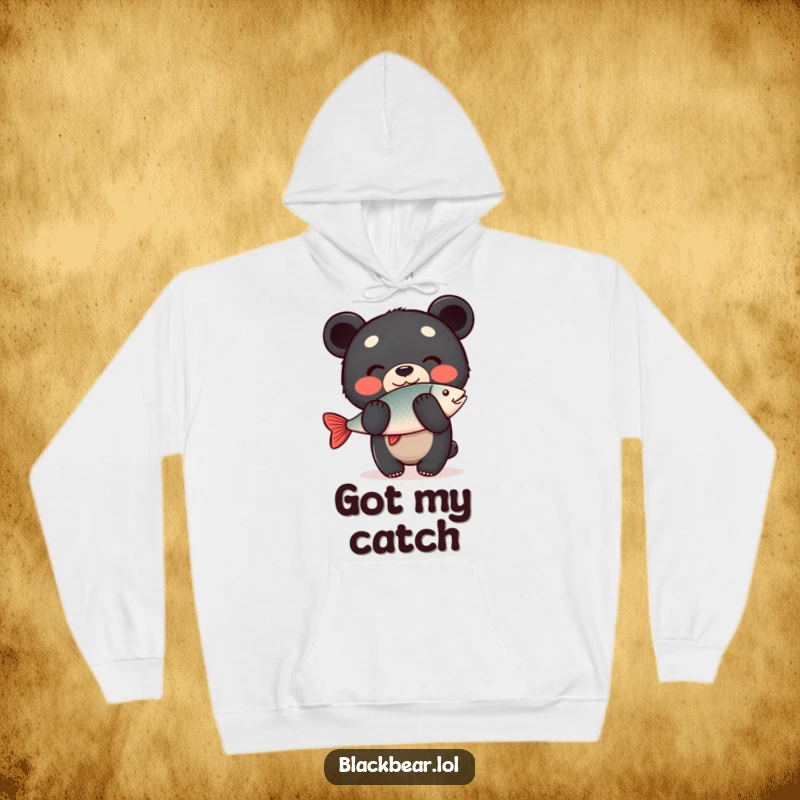 Funny Hoodie: A happy black bear cub balances a fish on its nose with a grin, designed for warmth and humorous charm.