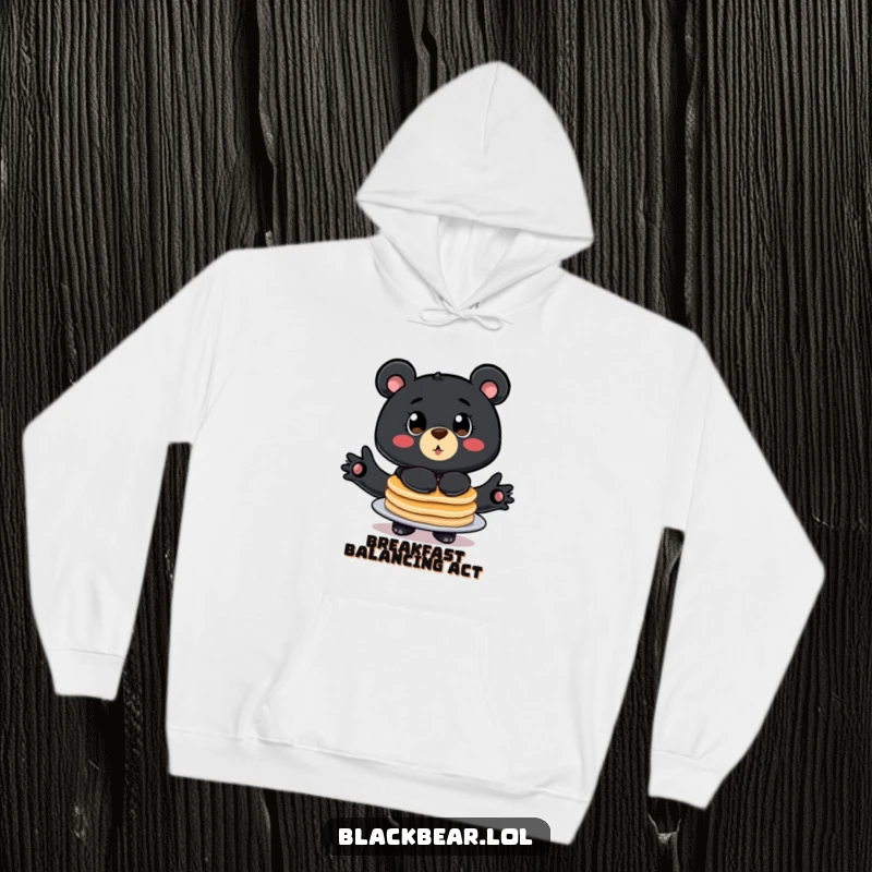 Funny hoodie featuring a big eyed bear comically balancing a stack of pancakes, perfect for cozy breakfast lovers.