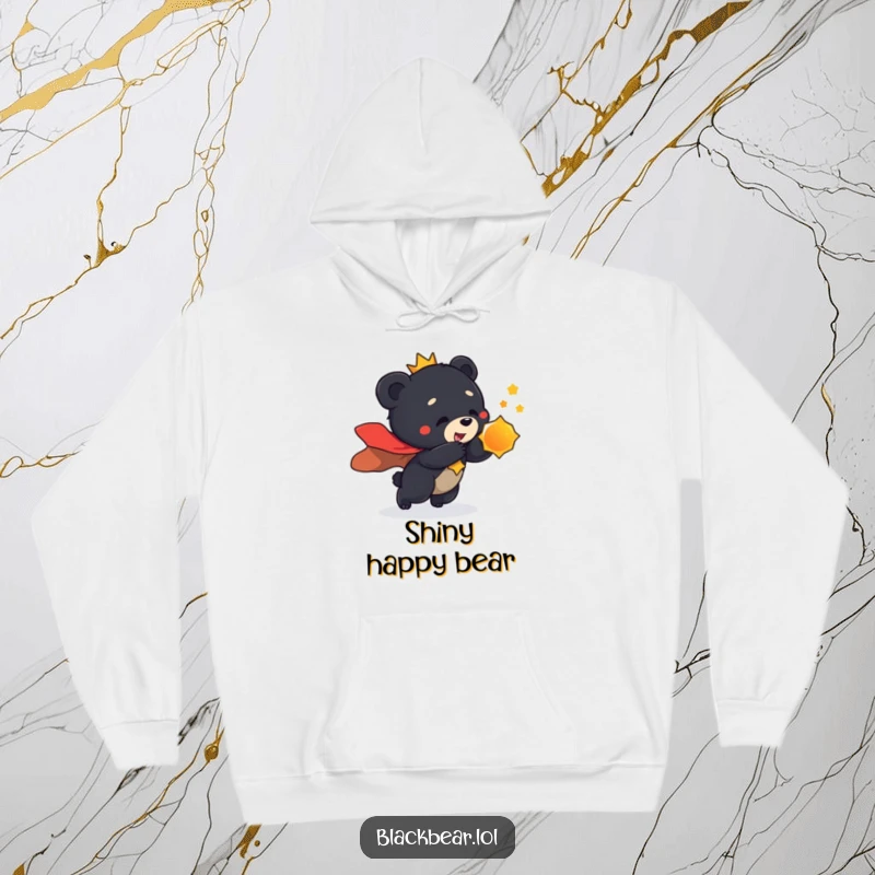 Funny hoodie print of a black bear cub adorned in a regal cape, playfully lunging towards a shiny, captivating object.