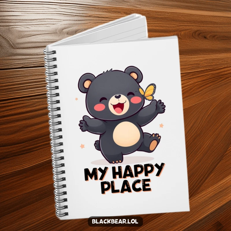 Funny notebook cover with a black bear cub happily dancing with a butterfly, ideal for journaling.
