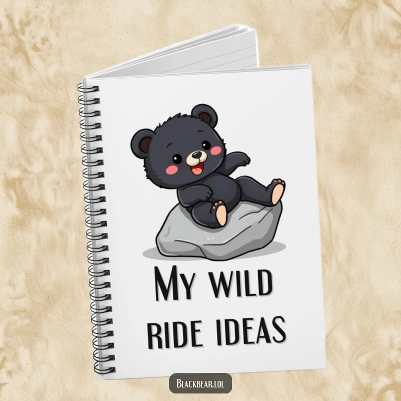 Funny Notebook cover featuring a black bear cub sliding down a rock with excitement, perfect for jotting down thrilling ideas.