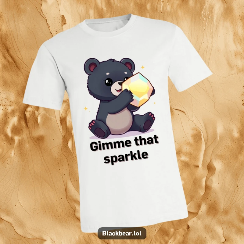 Funny t-shirt featuring a black bear cub stretching out to grab a large, captivating, shimmering gem.