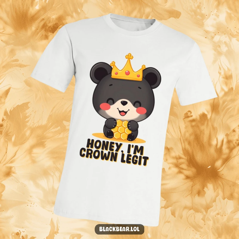 Funny t-shirt showcasing a joyful black bear cub in a small crown, delicately balancing a honeycomb on its nose with impressive skill.