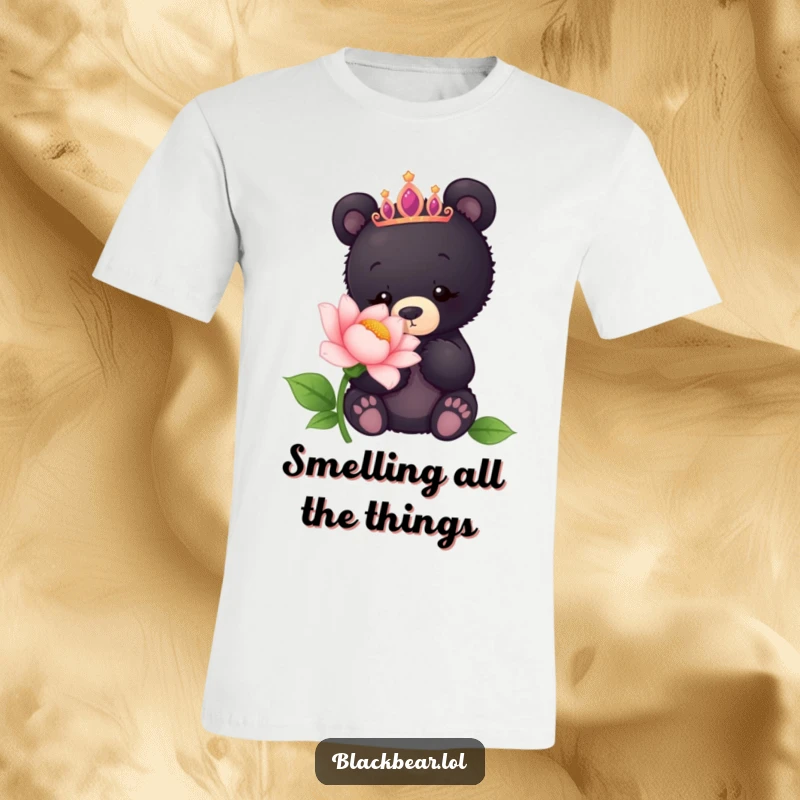 Funny t-shirt showing a curious black bear cub in a tiara sniffing a giant flower, embodying gentle exploration.