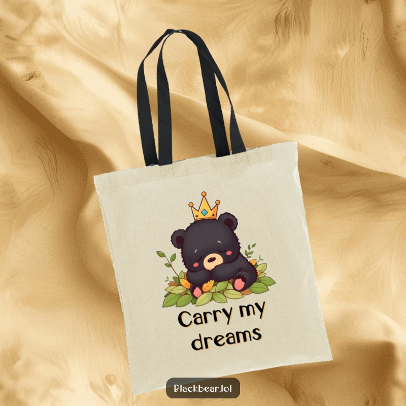 Funny crowned black bear cub napping peacefully in leaves, making this tote bag a symbol of relaxation and humor.