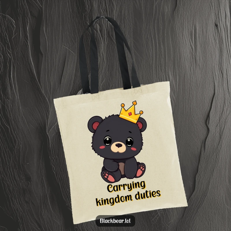 Funny tote bag with a black bear cub wearing a tiny crown and looking surprised, ideal for carrying items with royal flair.