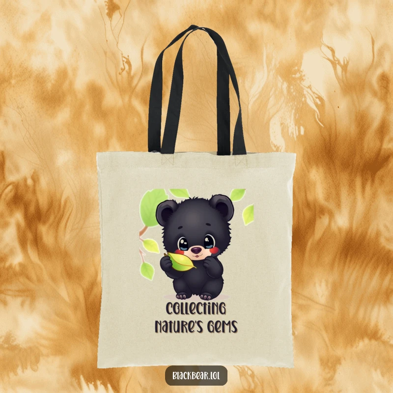 Funny tote bag featuring an adorable black bear cub with wide, curious eyes, inspecting a shimmering leaf, perfect for carrying your treasures.