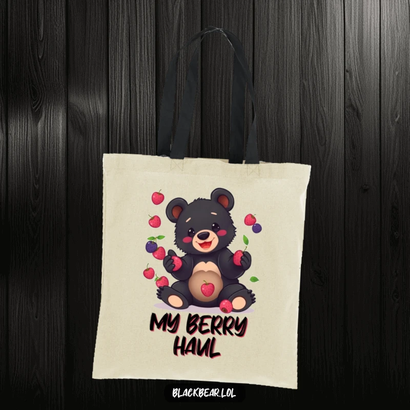 Funny Tote Bag print of a grinning black bear cub clumsily juggling a pile of berries, showcasing adorable disarray.