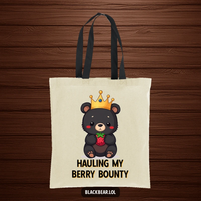 Funny black bear cub tote bag, a regal cub in a crown, balancing a berry on its nose, a humorous and practical accessory.