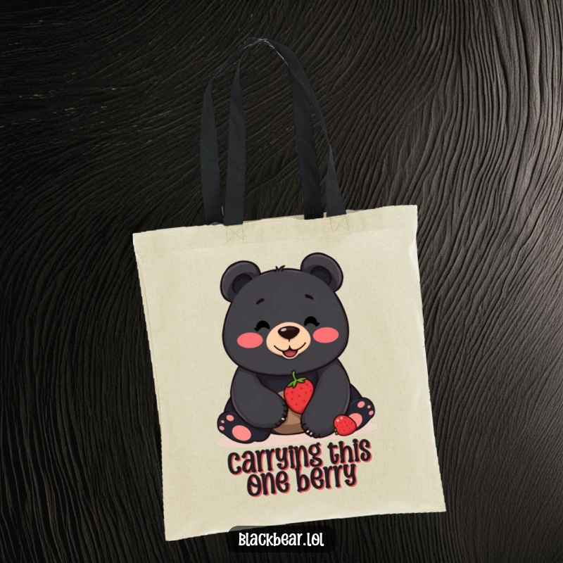 Funny tote bag with a smiling black bear balancing a single berry on its nose, perfect for carrying items with a humorous flair.