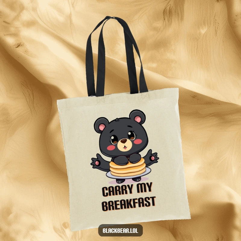 Funny tote bag with a stylized black bear, big eyes wide, comically balancing a stack of pancakes.
