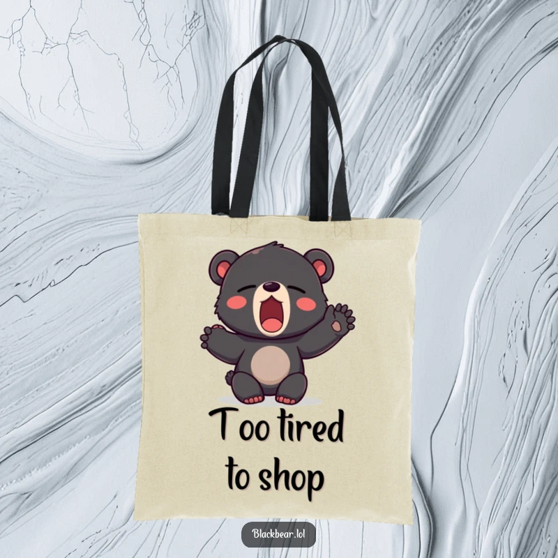 Funny tote bag illustrating a black bear cub yawning widely and stretching a paw, embodying a perfectly sleepy mood.